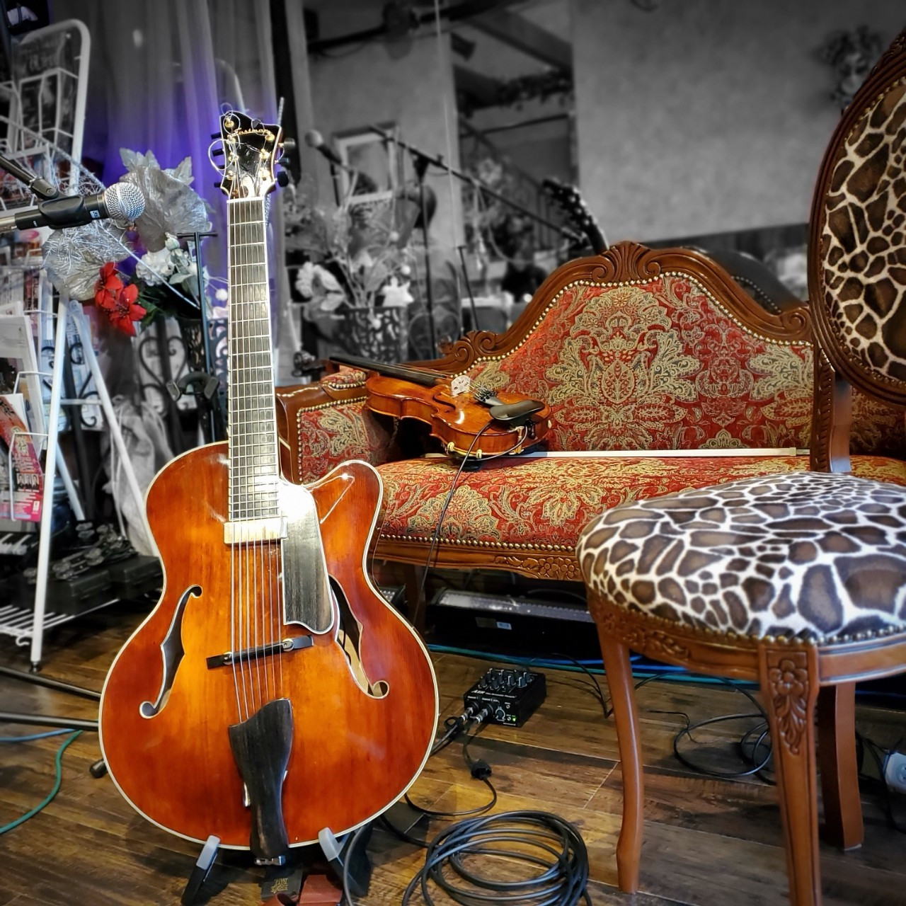 ギターとソファーに置かれたバイオリン画像
