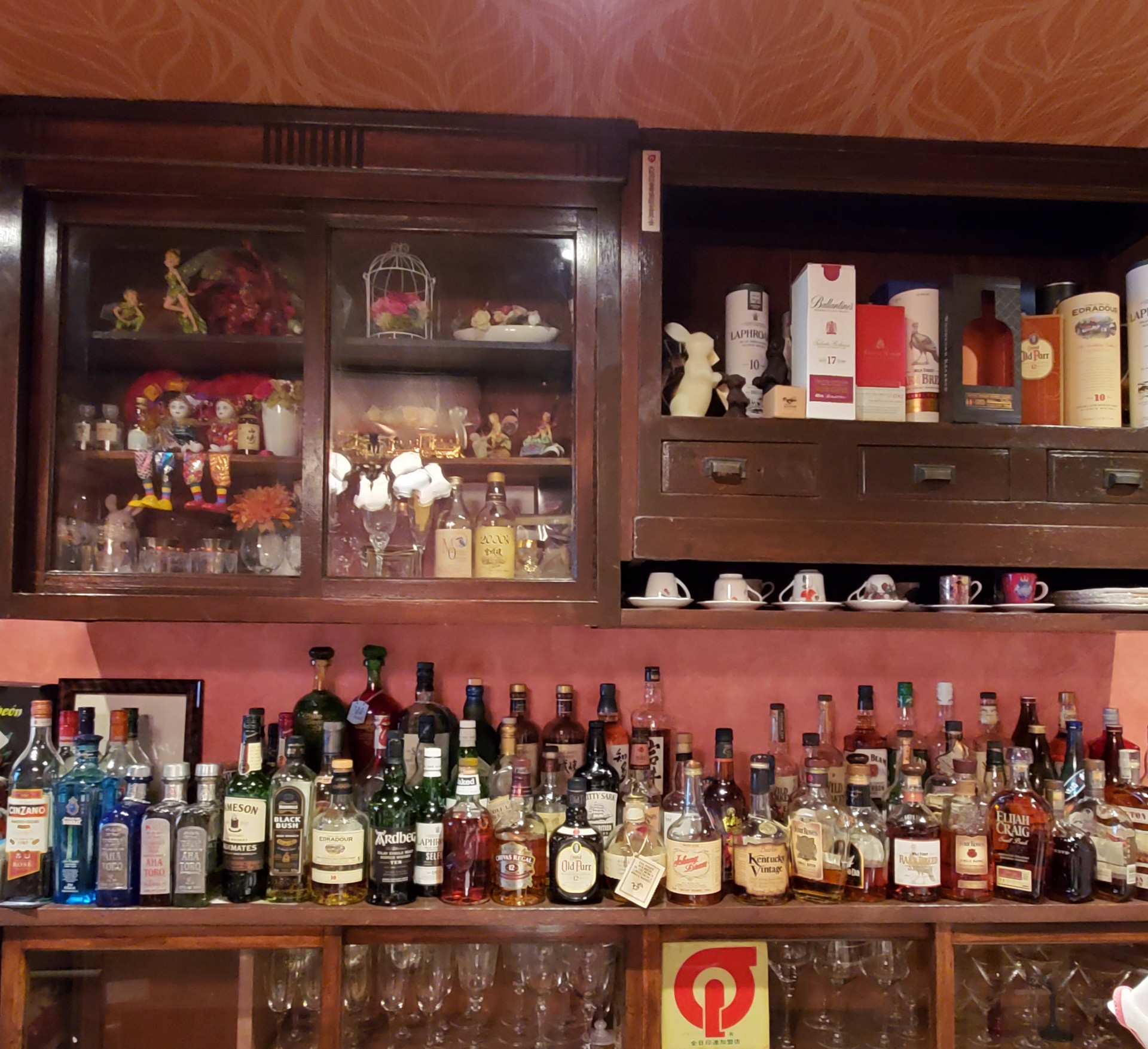 棚にあるウイスキーの数十本のボトル画像